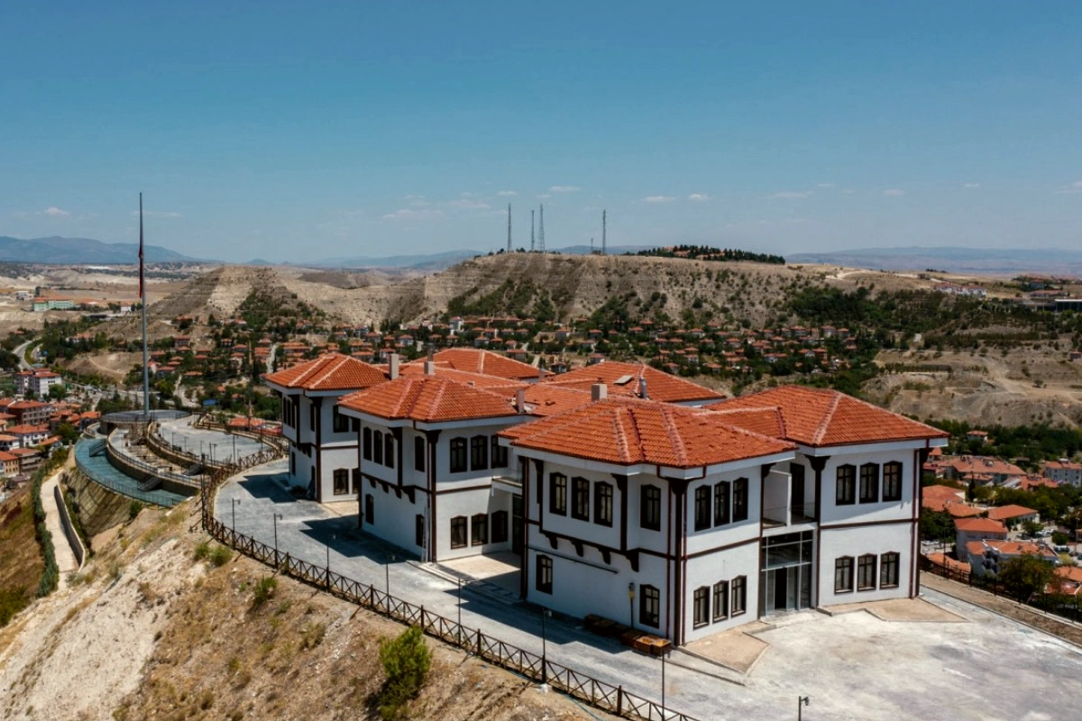 Yamaç üzerinde otel binası ve çevre peyzajı, havadan görünüm.