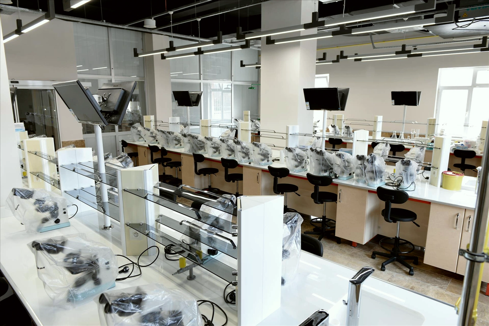 Tıp Fakültesi laboratuvarı; tezgâhlar, mikroskoplar ve havalandırma kanalları.